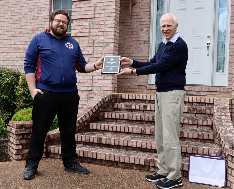 Graduating history major Christopher Hearn receives his History Major Award from Dr. Stephen Carls in May 2020.