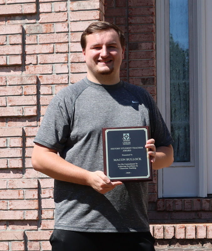 Graduating history major Macon Bullock holds his History Student Teacher Award which he received at a brief ceremony at Dr. Stephen Carls's home in May 2020.