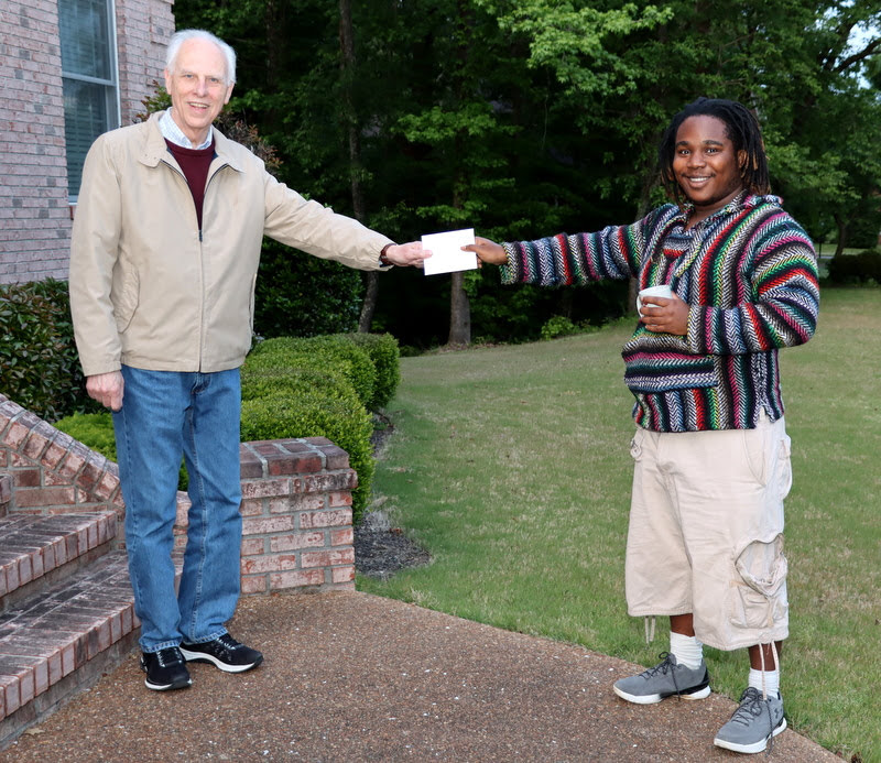 Graduating history major Trey Hall accepts a note of congratulations from Dr. Stephen Carls in May 2020. He also holds his history department mug that Carls gave him on the same occasion.