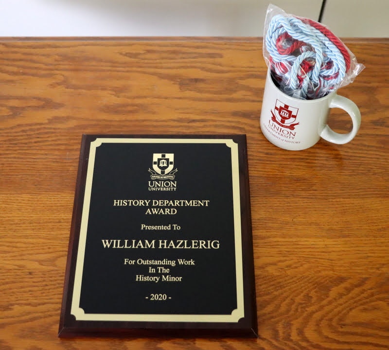 William Hazlerig received his History Minor Award, Phi Alpha Theta honor cord, and history department mug in the mail in May 2020.