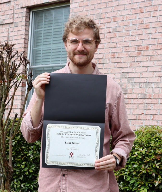 Luke Sower holds his first place award certificate for the Dr. James Alex Baggett History Research Paper Competition during a brief ceremony at Dr. Stephen Carls's home in May 2020.