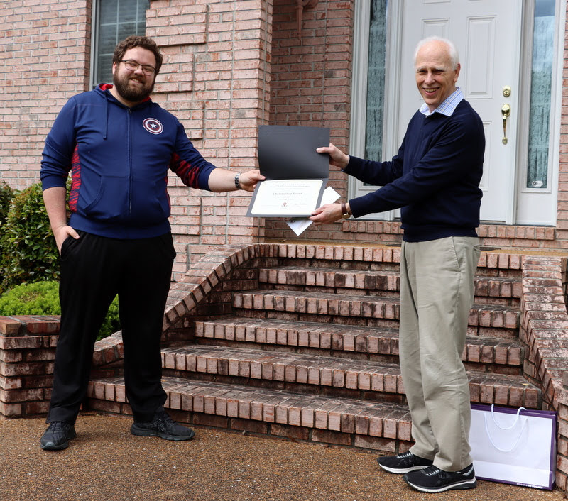 Christopher Hearn (left) accepts his Dr. James Alex Baggett History Research Paper Competition award certificate and check from Dr. Stephen Carls at a presentation ceremony in May 2020.
