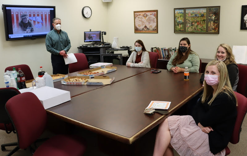 History club members prepare to enjoy pizza, soft drinks, and cupcakes together at their spring semester history movie night. They are (going clockwise starting on the left) Dr. Henry Allen, Davina Norris, Sandra Allen, Breanna Edmiston, and Mary Beth McGee.