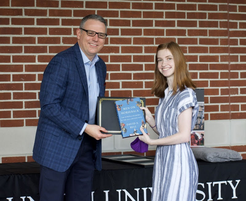 Savannah Wright accepts a book and certificate of commendation from Dr. Keith Bates on April 29, 2021, for her paper presentation at the Phi Alpha Theta Super-Regional Virtual Conference at the University of Arkansas on March 13. Photo by Naomi Mengel