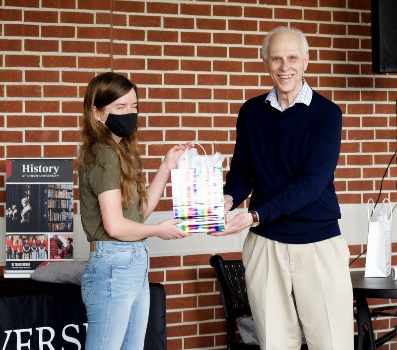Rebekah Lisle accepts a history gift award from Dr. Stephen Carls at the History Awards Program on April 29, 2021. Photo by Naomi Mengel