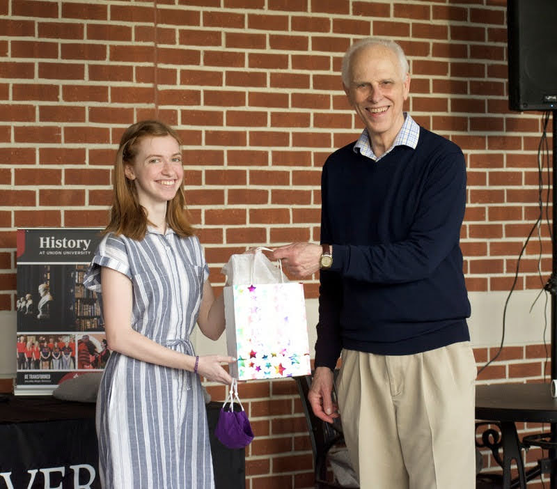 Dr. Stephen Carls presents a history gift award to graduating senior and Phi Alpha Theta member Savannah Wright on April 29, 2021. Photo by Naomi Mengel