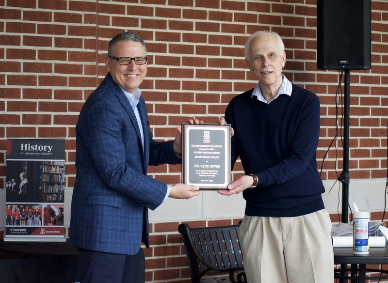 Dr. Keith Bates (left) accepts the History Alumni Distinguished Achievement Award from Dr. Stephen Carls at the History Awards Program on April 29, 2021. Photo by Naomi Mengel