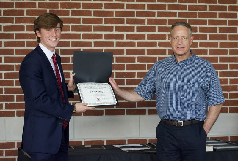 Tad Binkley (left) accepts an honorable mention certificate in the Dr. James Alex Baggett History Research Paper Competition from Dr. Henry Allen on April 29, 2021. Photo by Naomi Mengel