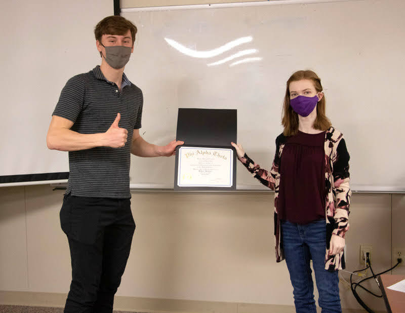 Tad Binkley receives his membership certificate in Phi Alpha Theta History Honor Society from Delta-Psi Chapter President Savannah Wright at the chapter's plenary meeting on March 10, 2021. Photo by Joey Echeverria