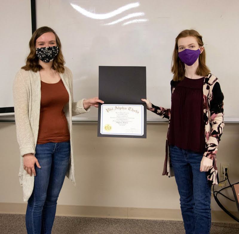 Abbie Hobson (left) accepts her Phi Alpha Theta membership certificate from Delta-Psi President Savannah Wright at the chapter's spring plenary meeting on March 10, 2021. Photo by Joey Echeverria