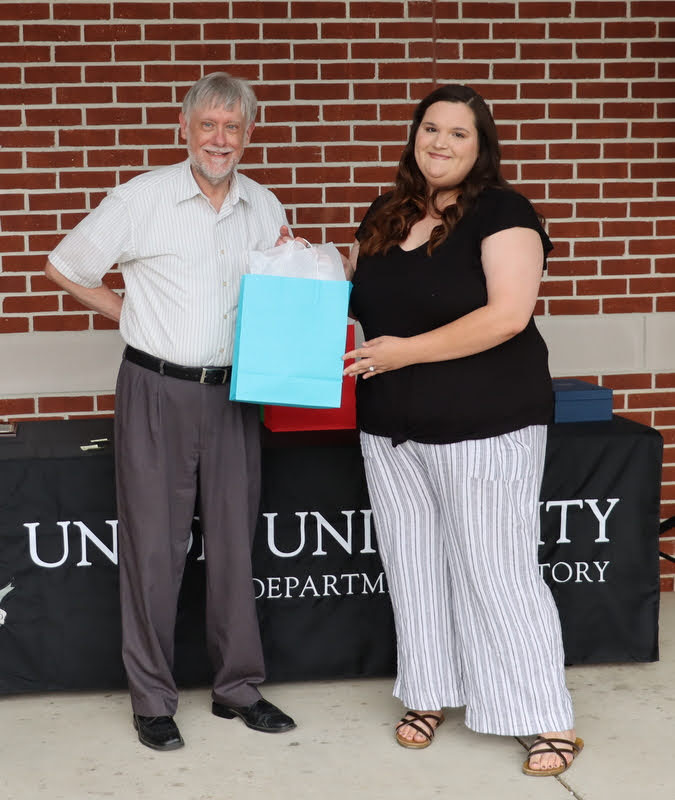 Graduating history major Sandra Allen receives a graduation gift award from Dr. Terry Lindley at the History Department Awards Program on April 28, 2022.