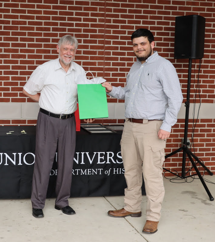 Graduating history major Dalton Lefave (right) accepts a graduation gift award from Dr. Terry Lindley at the History Department Awards Program on April 28, 2022.