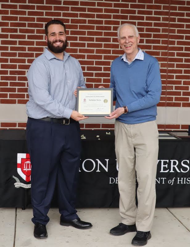 Nicholas Terra (left) accepts a certificate of appreciation from Dr. Stephen Carls at the History Department Awards Program on April 28, 2022, for his work as president of the Delta-Psi chapter of Phi Alpha Theta History Honor Society in 2021-2022.