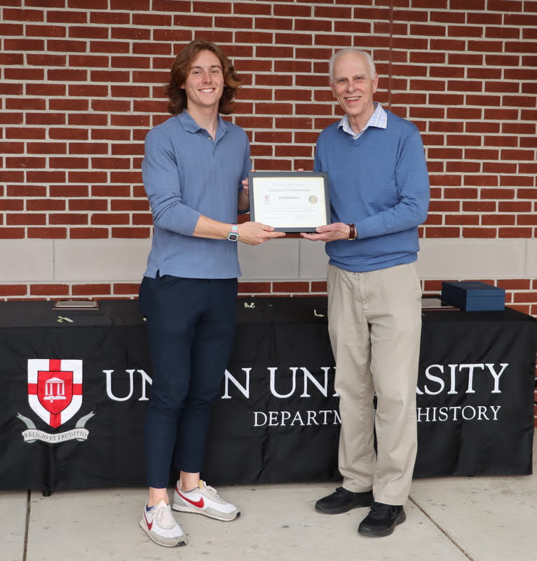 Dr. Stephen Carls (right) presents a certificate of appreciation to Tad Binkley at the History Department Awards Program on April 28, 2022, for his work as vice president of the Delta-Psi chapter of Phi Alpha Theta History Honor Society in 2021-2022.
