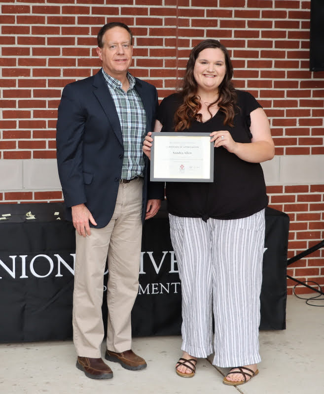 Sandra Allen accepts a certificate of appreciation from Dr. Henry Allen at the History Department Awards Program on April 28, 2022, for her work as president of the Rutledge Honorary History Club in 2021-2022.