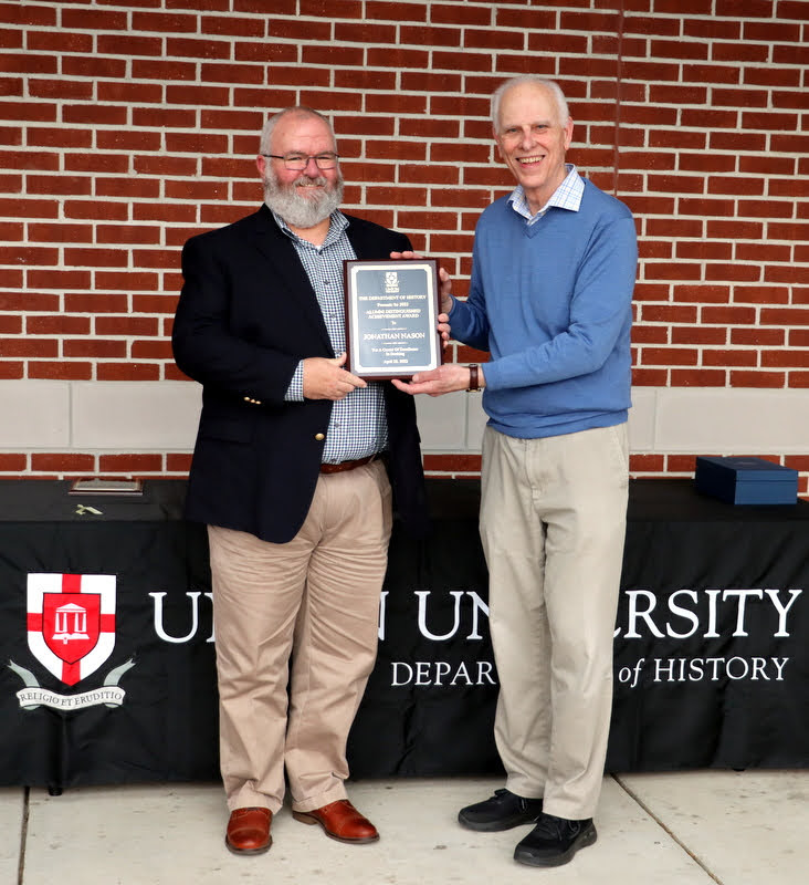 Jonathan Nason (left) accepts the Fourteenth Annual History Alumni Distinguished Achievement Award from Dr. Stephen Carls at the History Department Awards Program on April 28, 2022, for his career of excellence in banking.