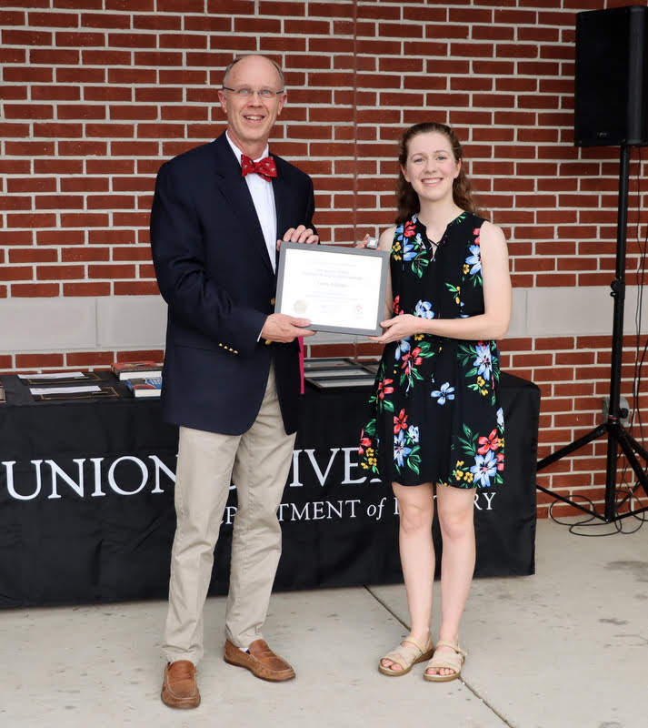 Robert Briley presents the Phi Alpha Theta Scholarship Pin and Academic Excellence Certificate to Anne Adams at the History Department Awards Program  on April 28, 2022.