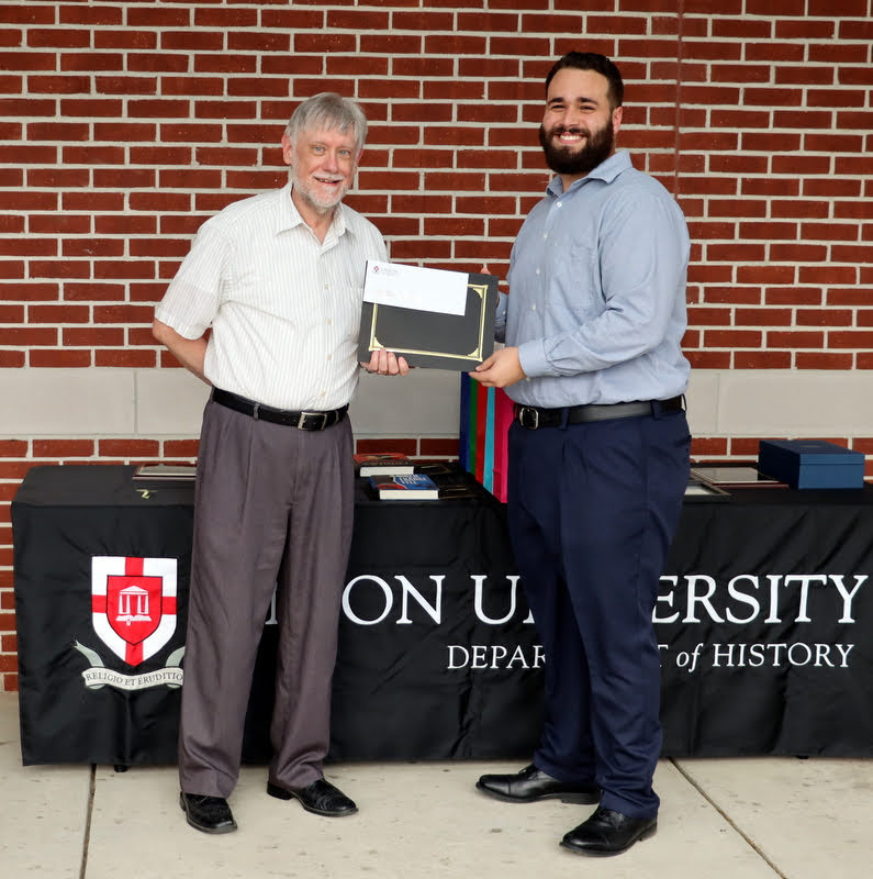 Dr. Terry Lindley presents the second place prize in the 2022 Dr. James Alex Baggett History Research Paper Competition to Nicholas Terra at the History Department Awards Program on April 28, 2022.