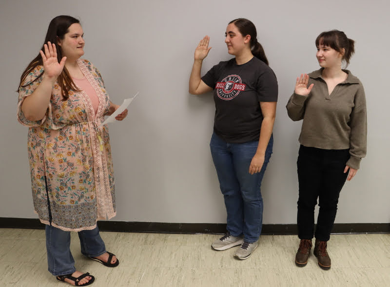 Club President Sandra Allen (left) leads Joy Brown (center) and Sophia Keskeys in the club's membership pledge on April 7, 2022.