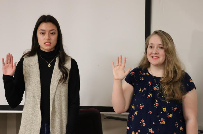 Makayla Baker (left) and Breanna Edmiston take the Phi Alpha Theta membership oath at the Delta-Psi chapter's spring initiation/plenary meeting on February 28, 2022. Photo by Stephen Carls
