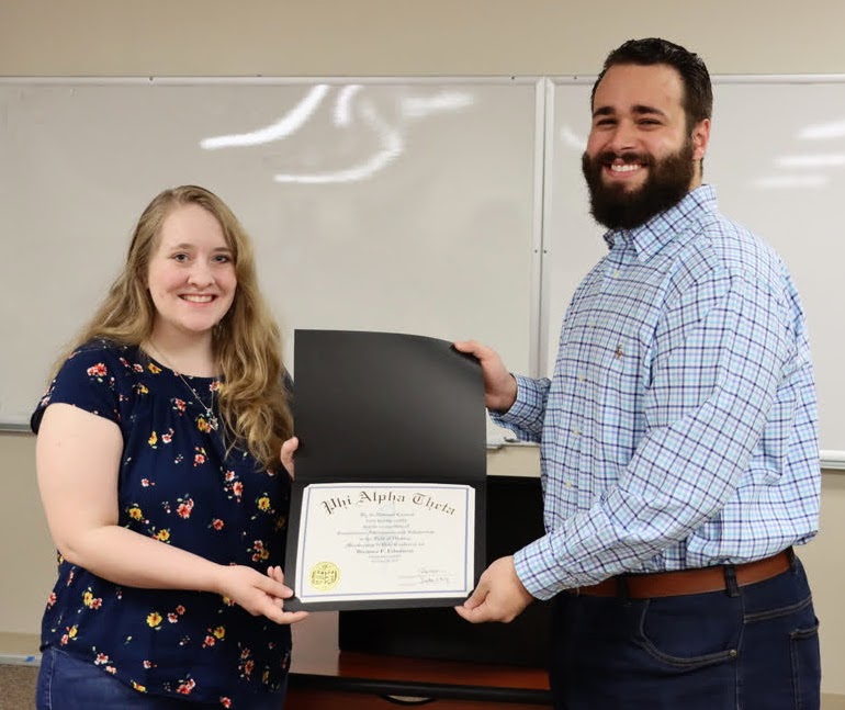 New member Breanna Edmiston accepts her Phi Alpha Theta membership certificate from Delta-Psi President Nick Terra at the society's spring initiation/plenary meeting on February 28, 2022. Photo by Stephen Carls