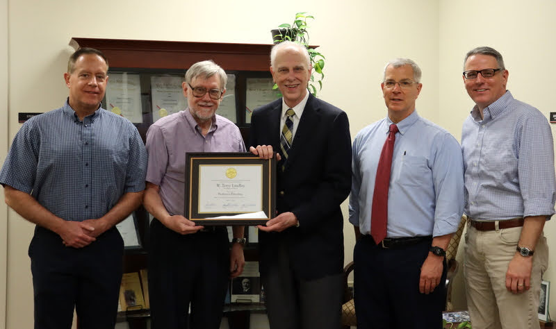 Dr. Terry Lindley (second from left) accepts his professor emeritus diploma from Dr. Stephen Carls (center) on May 11, 2022. Other history department faculty members present for the occasion are Dr. Henry Allen (left), Dr. David Thomas (second from right), and Dr. Keith Bates (right).