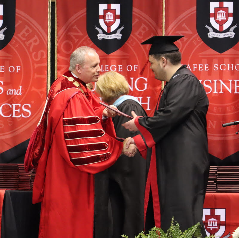Dalton Lefave accepts congratulations and his bachelor of science diploma from Union President Samuel W. Dub Oliver at the undergraduate commencement ceremony on May 21, 2022.