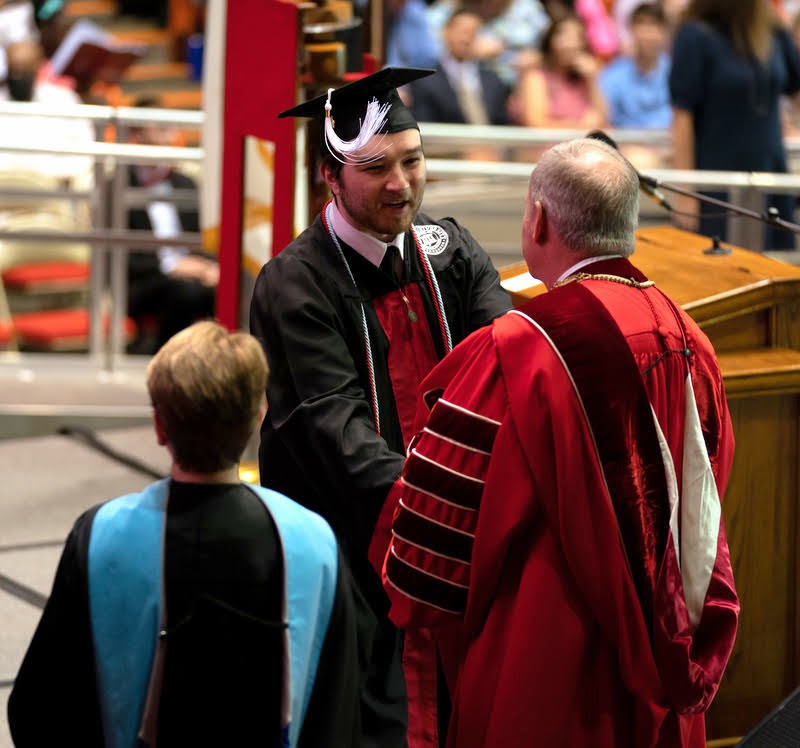 Walker Beasley accepts congratulations and his bachelor of arts diploma from Union President Samuel W. Dub Oliver at the school's undergraduate commencement ceremony on May 21, 2022. Photo by Kristi Woody