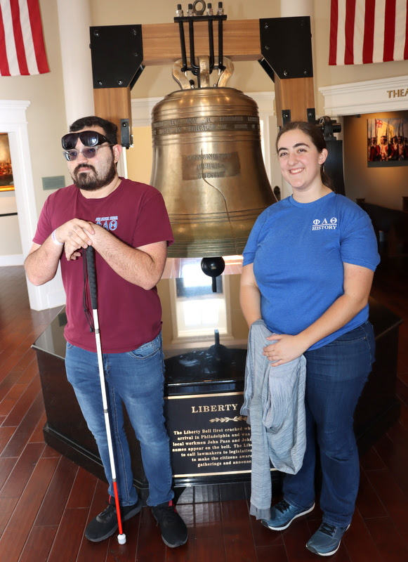 Chris Young and Joy Brown stand in front of a replica of the Liberty Bell in Liberty Hall on Freedom Square at Discovery Park of America on April 1, 2023.