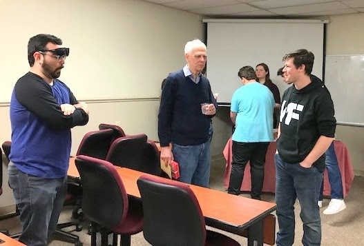 Dr. Stephen Carls (center) talks with Union student Noah Kea (right) at his surprise retirement party on April 24, 2023. Phi Alpha Theta member Christian Young (left) also enjoys the fun.