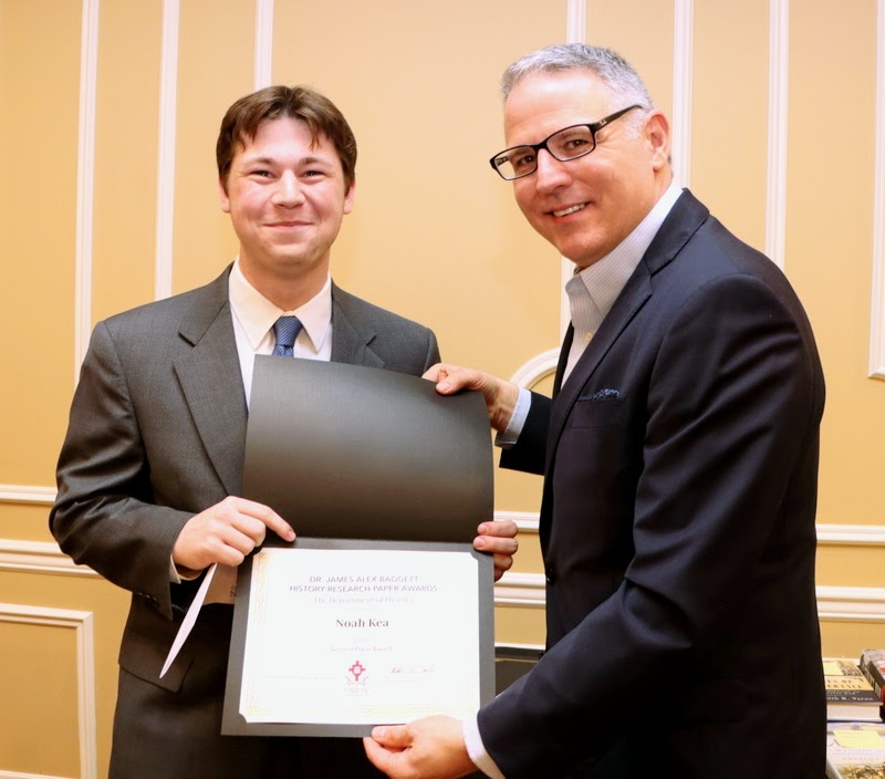 Noah Kea (left) accepts the second place award (a certificate and a check) in the Dr. James Alex Baggett History Research Paper Competition from Dr. Keith Bates at the History Department Awards Banquet on April 27, 2023.