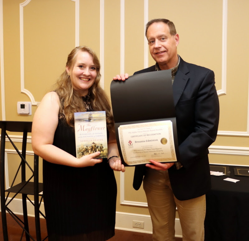 Breanna Edmiston accepts a book and certificate of recognition from Dr. Henry Allen at the History Department Awards Banquet on April 27, 2023,  for the excellent paper she presented at the Kentucky Phi Alpha Theta Regional Conference on April 15, 2023.