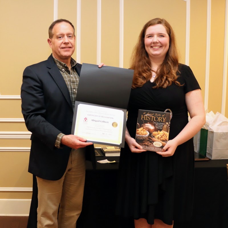 Abigail Gilbert receives a book and certificate of recognition from Dr. Henry Allen at the History Department Awards Banquet on April 27, 2023, for the excellent paper she presented at the Kentucky Phi Alpha Theta Regional Conference on April 15, 2023.