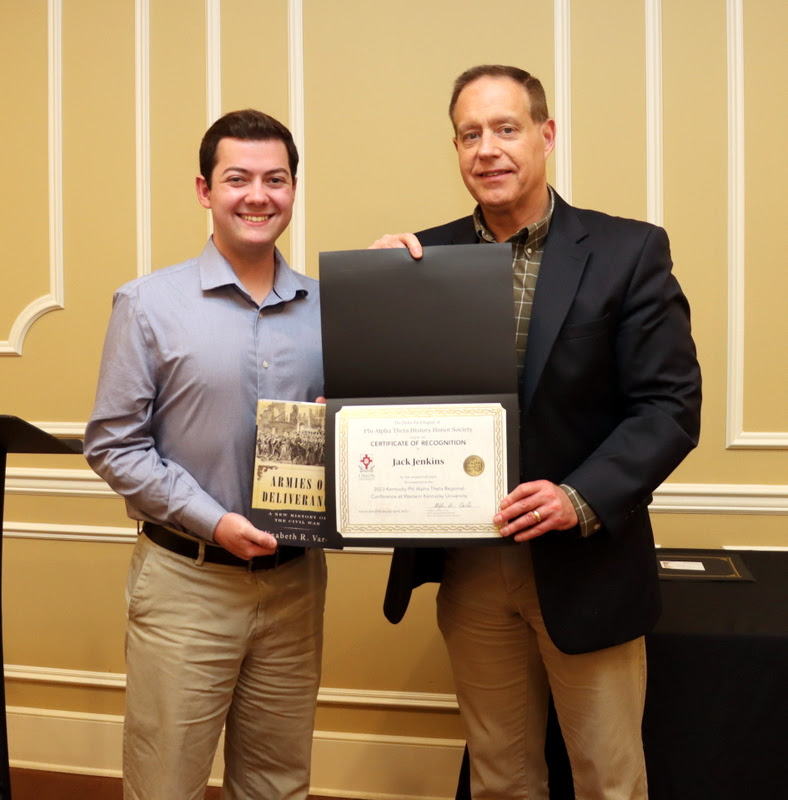 Jack Jenkins (left) accepts a book and a certificate of recognition from Dr. Henry Allen at the History Department Awards Banquet on April 27, 2023, for the excellent paper he presented at the Kentucky Phi Alpha Theta Regional Conference on April 15, 2023.