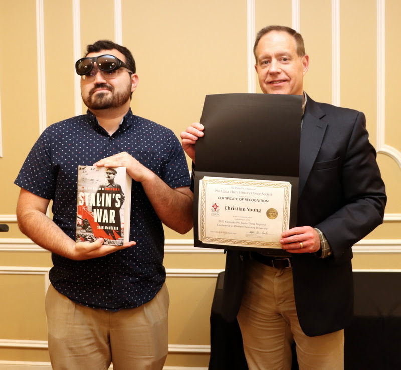 Christian Young (left) accepts a book and certificate of recognition from Dr. Henry Allen at the History Department Awards Banquet on April 27, 2023, for the excellent paper he presented at the Kentucky Phi Alpha Theta Regional Conference on April 15, 2023.