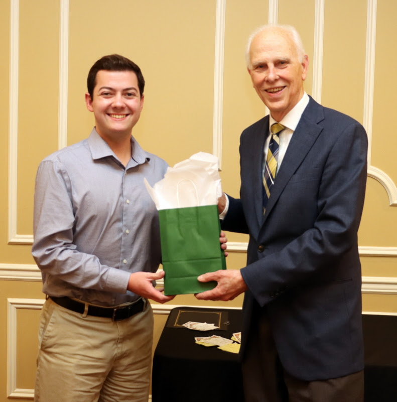 History major and Phi Alpha Theta member Jack Jenkins receives a gift award bag from Dr. Stephen Carls at the History Department Awards Banquet on April 27, 2023.