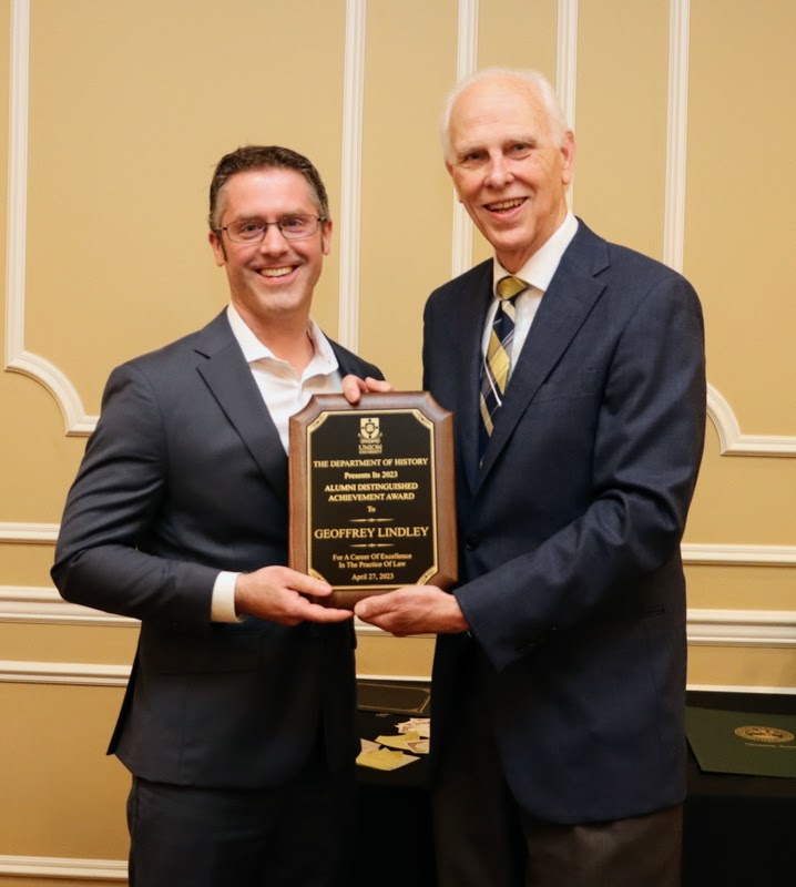 Geoffrey Lindley accepts the Fifteenth Annual History Alumni Distinguished Achievement Award from Dr. Stephen Carls at the History Department Awards Banquet on April 27, 2023.