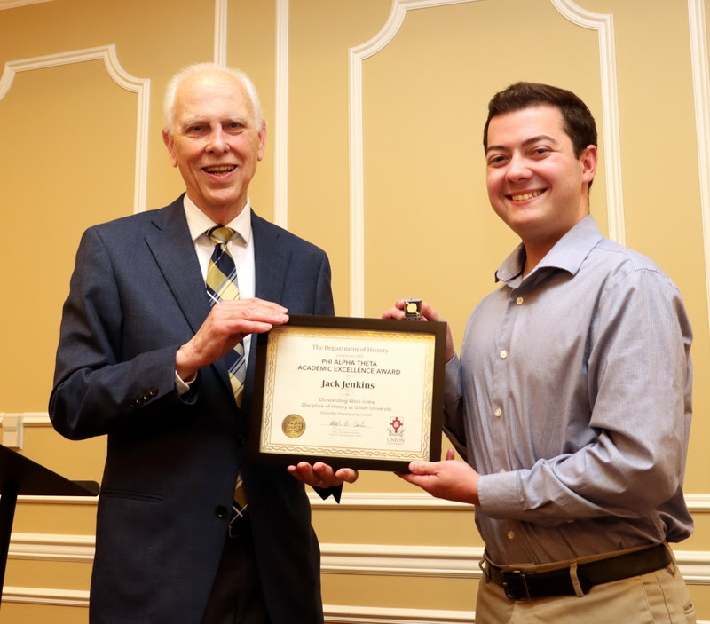 Jack Jenkins (right) accepts the Phi Alpha Theta Scholarship Pin and Academic Excellence Certificate for outstanding work in his history courses at Union from Dr. Stephen Carls at the History Department Awards Banquet on April 27, 2023.