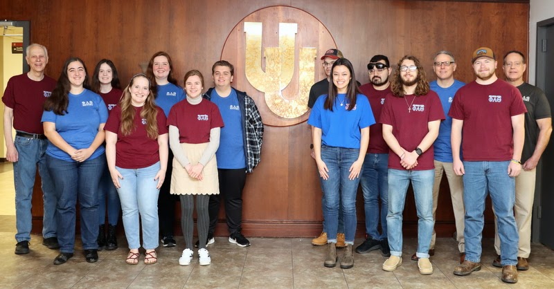 Participants in the Delta-Psi chapter's Annual Phi Alpha Theta T-shirt Spirit Day on March 20, 2023, pose for a photo in Union University's chapel foyer. They are (left to right): Dr. Stephen Carls, Joy Brown, Samantha Poore, Breanna Edmiston, Abigail Gilbert, Anna Yadkowski, Austin Alexander, William Houston, Makayla Baker, Christian Young, Nicholas Palmer, Dr. Keith Bates, John Garland, and Dr. Henry Allen.