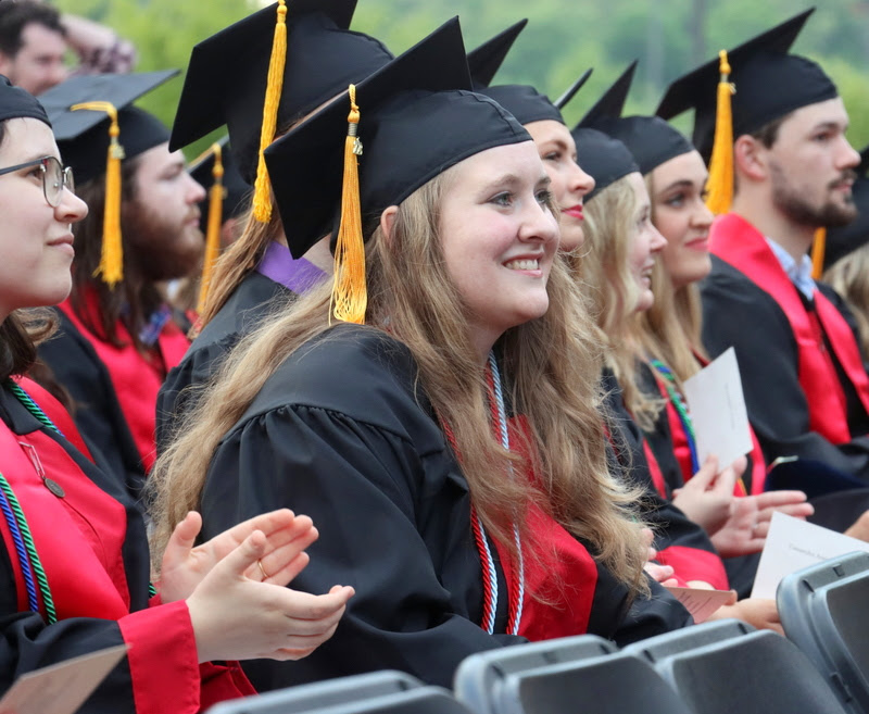 Graduating history major and Phi Alpha Theta member Breanna Edmiston (leaning forward) waits for her moment to go on stage at Union University's spring undergraduate commencement service on May 6, 2023, to receive her diploma for completing a Bachelor of Science degree.