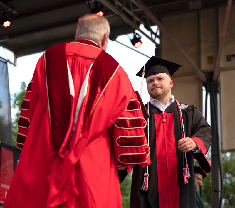 History minor and Phi Alpha Theta member John Garland accepts his diploma for completing a Bachelor of Arts degree program from Union University President Samuel W. Dub Oliver at the school's spring undergraduate commencement service on May 6, 2023.