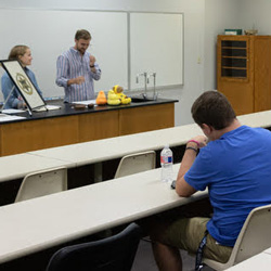 Phi Alpha Theta President Luke Sower (standing behind the counter) begins the Delta-Psi chapter's fall initiation/plenary meeting on September 24, 2019. Vice President Megan Ledbetter is at his side. Photo by Joey Echeverria