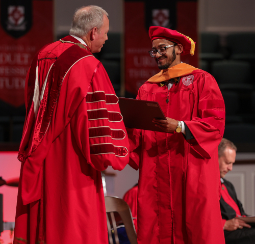 Charles Melvin Banks III receives his Doctor of Nursing Practice degree from Union President Samuel W. "Dub" Oliver during the July 29 commencement ceremony. (Photo by Eli Creasy)