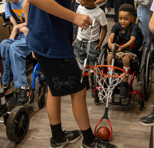 Noah Shaw, age 5, uses a pair of "grabbers" that a student team designed for him as part of the Make:able challenge. (Photo by Karley Hathcock)