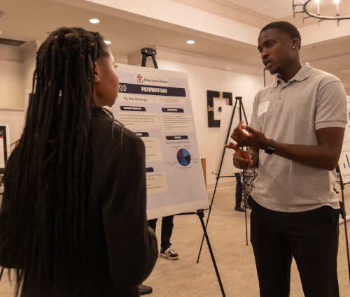 Senior finance major Wesley Mhlanga discusses his research at the Scholarship Symposium March 31. (Photo by Karley Hathcock)
