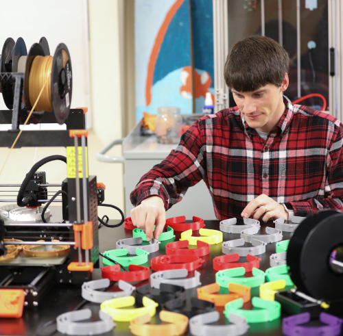 Georg Pingen, associate professor of engineering, is using the university’s 3D printers to produce a specific component to face shields being used by medical personnel. (Photo by Kristi Woody) 