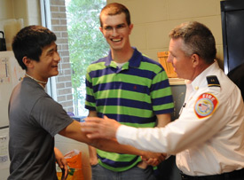 Captain Johnny Brantley, of the Jackson Fire Department, greets Union students Danny Song (left) and Kevin Furniss during a March 14 gathering at the Vann Drive fire station for Union students and the firefighters who rescued them Feb. 5. (Photo by Morris Abernathy)