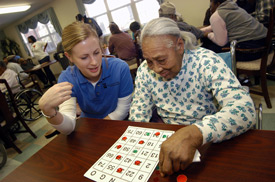 Union student Heather Moellman helps 88-year-old Maggie Johnson during a bingo game at the Mission Convalescent Center in Jackson. (Photo by Morris Abernathy)