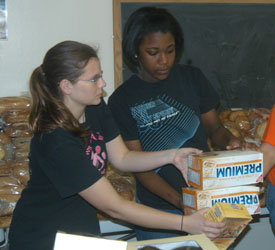 Union freshman Sarah Porter (left) and sophomore Nar’Asha Randall (right) prepare food for distribution at the Sumner County Food Bank. (Photo by Tim Ellsworth)