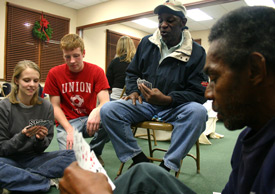 Union students Emily Watlington (left) and Andrew Griffith play cards with Donelle and Glenn during the "Room in the Inn" event Dec. 7 on Union's campus. Union hosted 17 men from Jackson's homeless community, providing them with food, showers and a place to sleep. (Photo by Stephanie Schroeder)